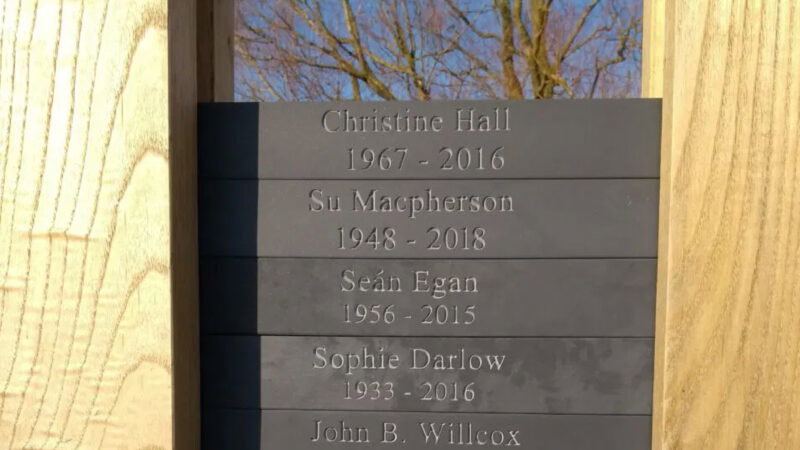 Aylesbury Vale natural burial memorials honour lives with engraved plaques—displaying names and years: Christine Hall (1967–2016), Su Macpherson (1948–2018), Seán Egan (1956–2015), Sophie Darlow (1933–2016), and John B. Willcox.